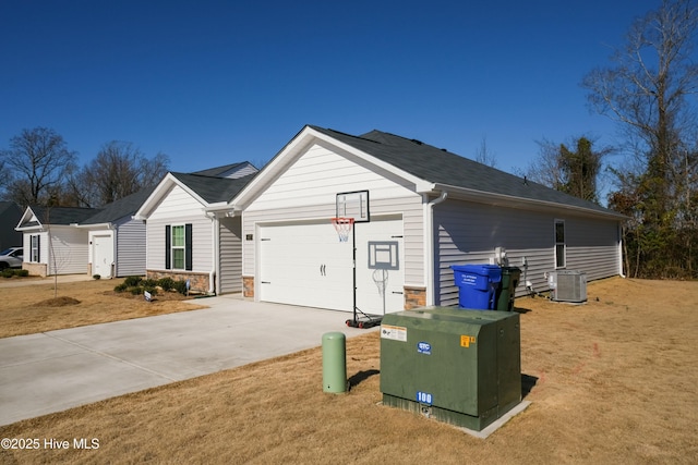 view of side of home with a garage, a yard, and central AC