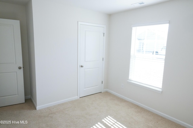 spare room featuring light carpet