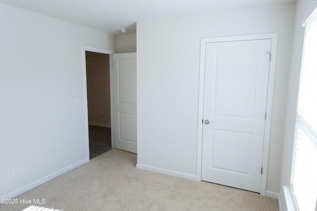 unfurnished bedroom featuring light carpet