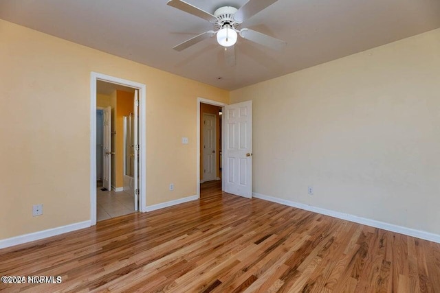 unfurnished bedroom with ensuite bath, light hardwood / wood-style flooring, and ceiling fan