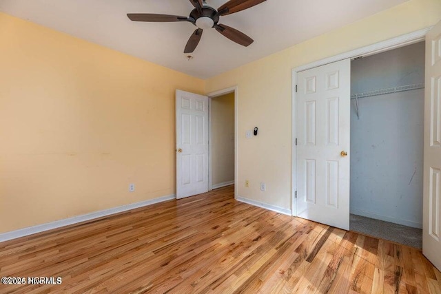 unfurnished bedroom featuring ceiling fan, a closet, and light hardwood / wood-style flooring