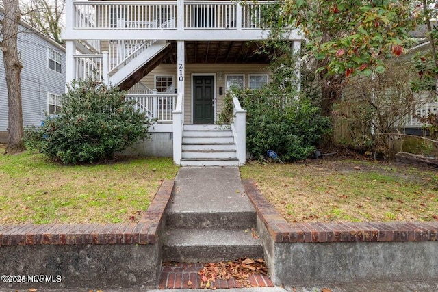 doorway to property with a lawn