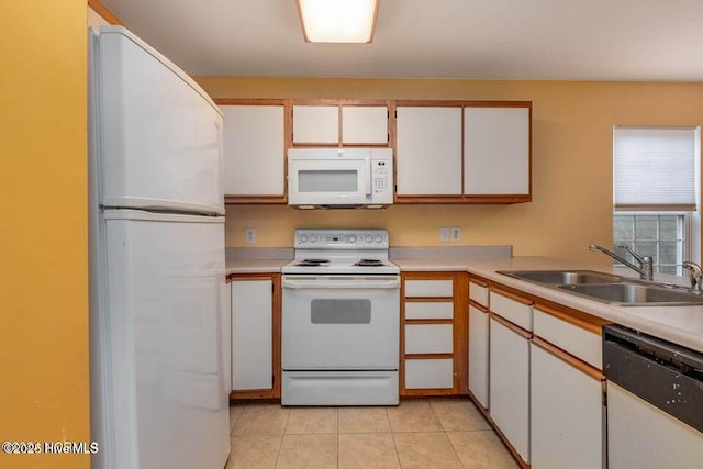 kitchen featuring light tile patterned flooring, sink, white cabinets, and white appliances