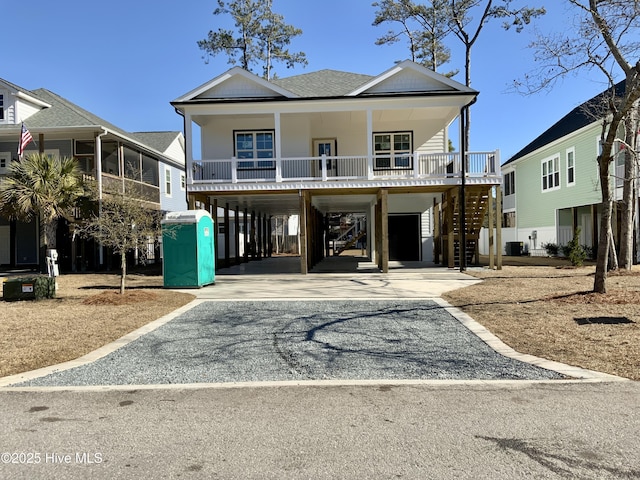 coastal inspired home with a carport, a porch, and central AC unit