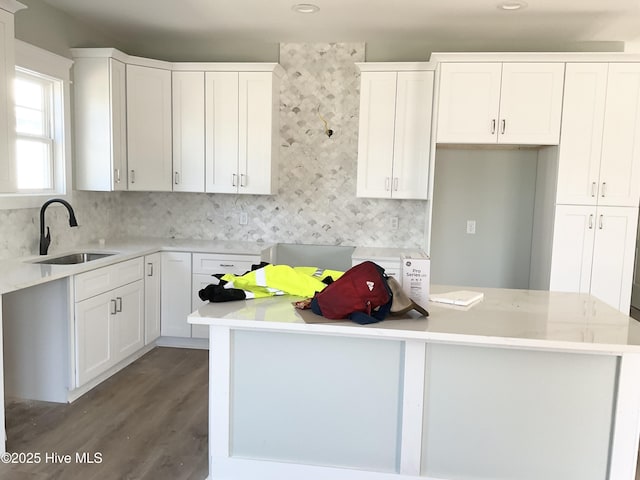 kitchen featuring white cabinetry, sink, and backsplash