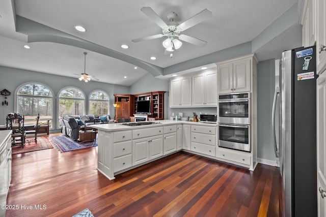 kitchen with stainless steel appliances, white cabinetry, dark hardwood / wood-style flooring, and kitchen peninsula