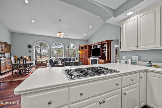 kitchen featuring white cabinets, kitchen peninsula, stainless steel gas stovetop, and ceiling fan