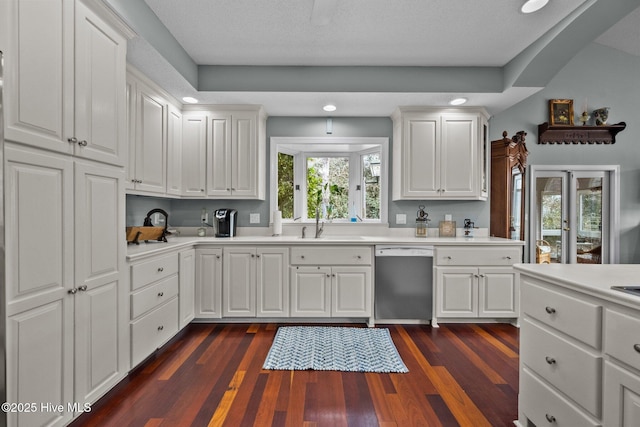 kitchen featuring dark hardwood / wood-style flooring, dishwasher, sink, and white cabinets