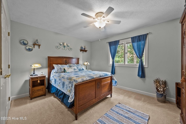 bedroom featuring ceiling fan, light colored carpet, and a textured ceiling