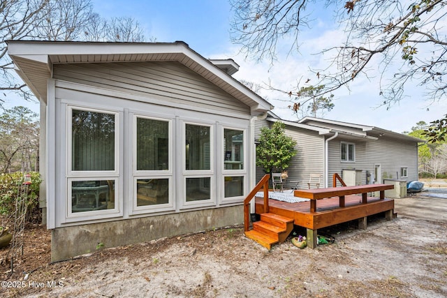 rear view of house featuring a wooden deck