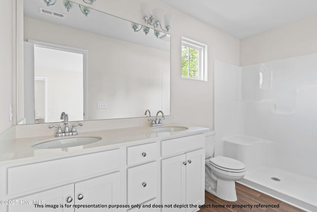 bathroom featuring walk in shower, wood-type flooring, toilet, and vanity