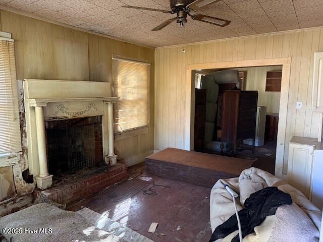 living room featuring ornamental molding, a fireplace, and wood walls