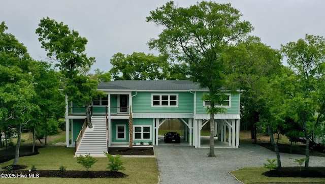 132 N Middleton Ave, Oak Island, NC 28465 - coastal inspired home with roof with shingles, a carport, gravel driveway, and stairs