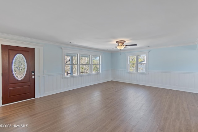 entrance foyer featuring crown molding, ceiling fan, and light wood-type flooring