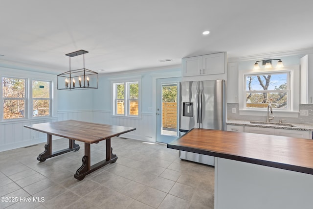 tiled dining space featuring ornamental molding and sink