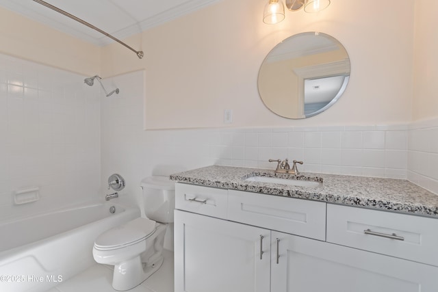 full bathroom with tiled shower / bath, tile walls, vanity, toilet, and crown molding