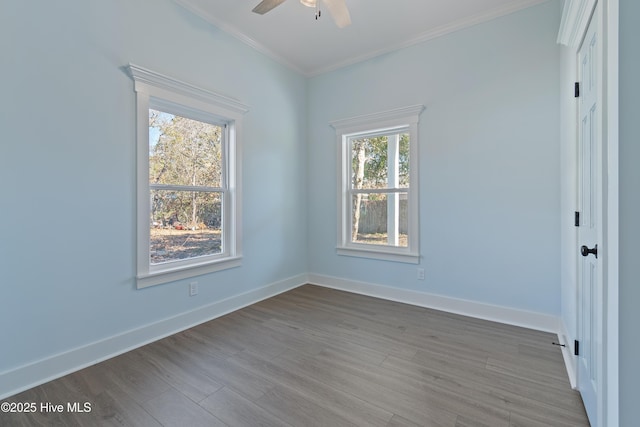 spare room with crown molding, plenty of natural light, and hardwood / wood-style flooring