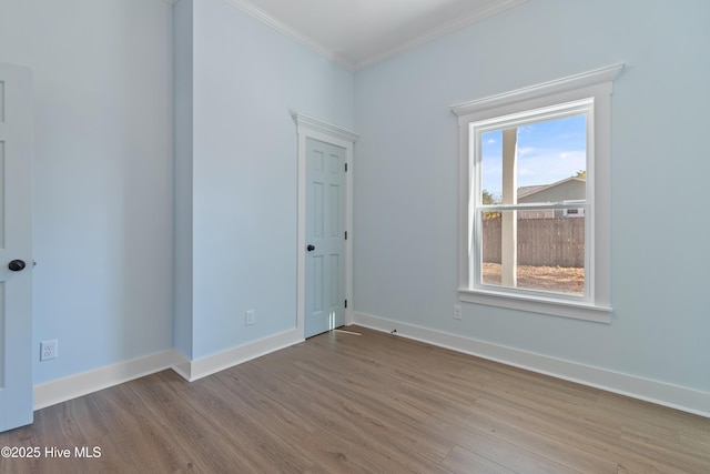 empty room with light hardwood / wood-style flooring and ornamental molding