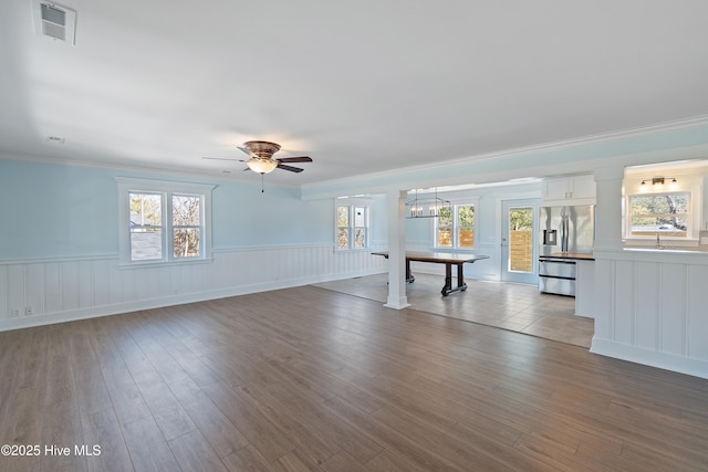 interior space with crown molding, ceiling fan with notable chandelier, and light hardwood / wood-style floors