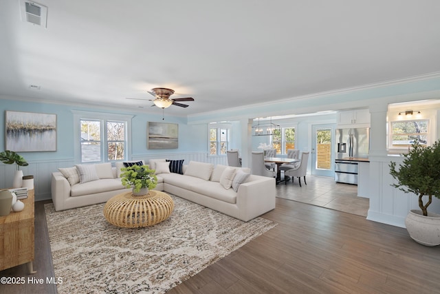 living room with hardwood / wood-style floors, crown molding, and ceiling fan