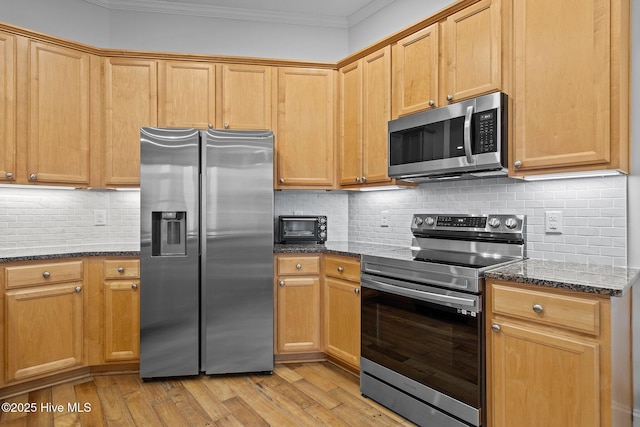 kitchen featuring stainless steel appliances, dark stone countertops, and backsplash