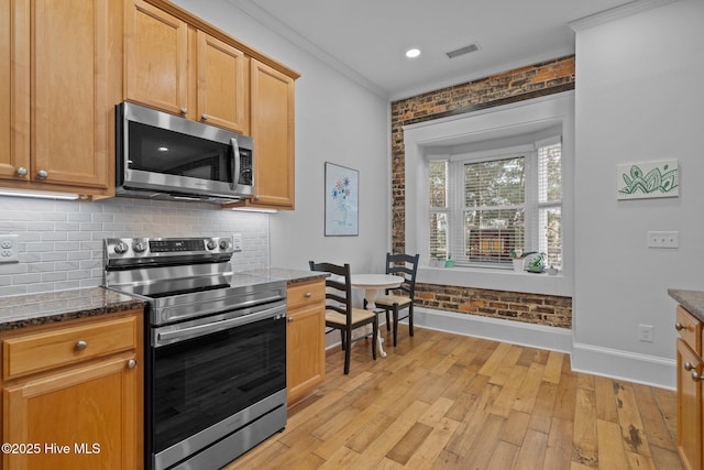 kitchen featuring stainless steel appliances, crown molding, brick wall, and light hardwood / wood-style flooring