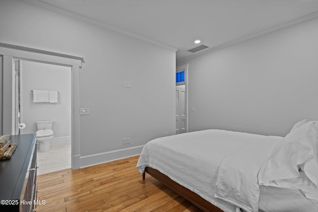 bedroom with crown molding, ensuite bath, and light hardwood / wood-style floors