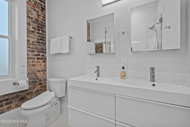 bathroom featuring vanity, brick wall, walk in shower, and toilet