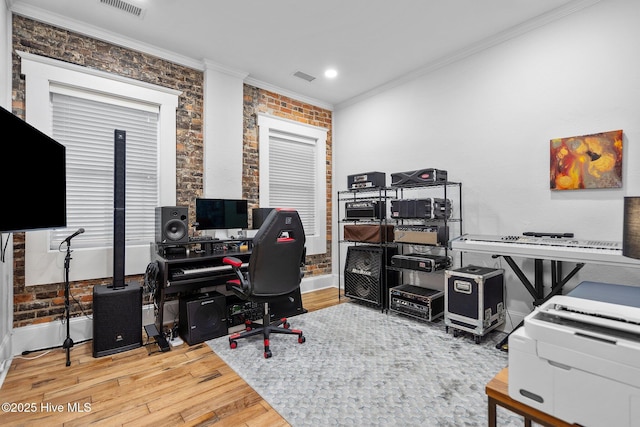 office space with crown molding, brick wall, and wood-type flooring