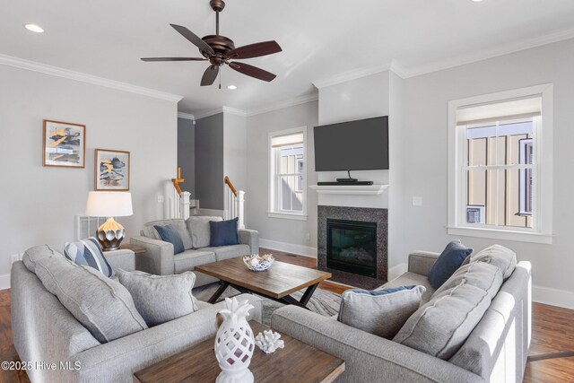 living room with hardwood / wood-style flooring, ornamental molding, and ceiling fan