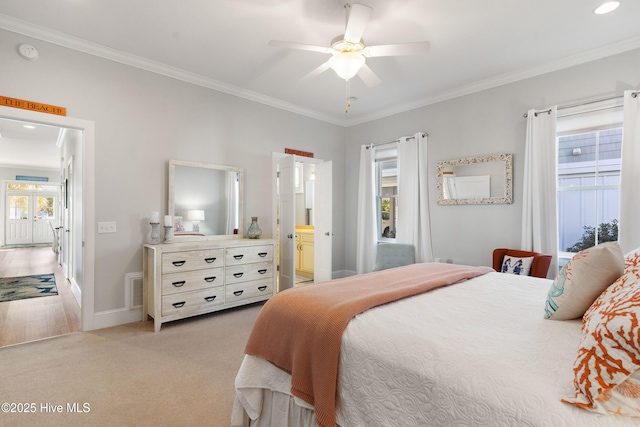 carpeted bedroom featuring multiple windows, crown molding, ceiling fan, and ensuite bathroom