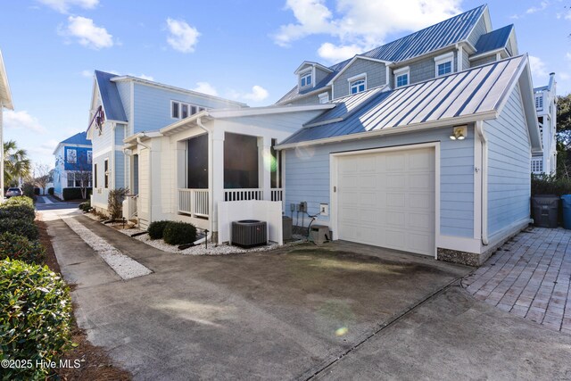 view of front of home with central AC unit and a garage