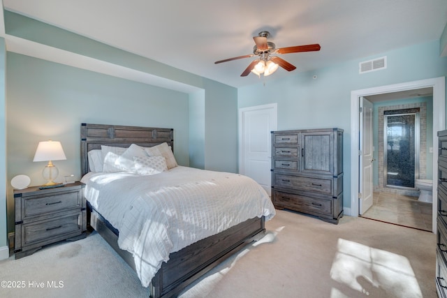 bedroom featuring light carpet, visible vents, a ceiling fan, and ensuite bathroom