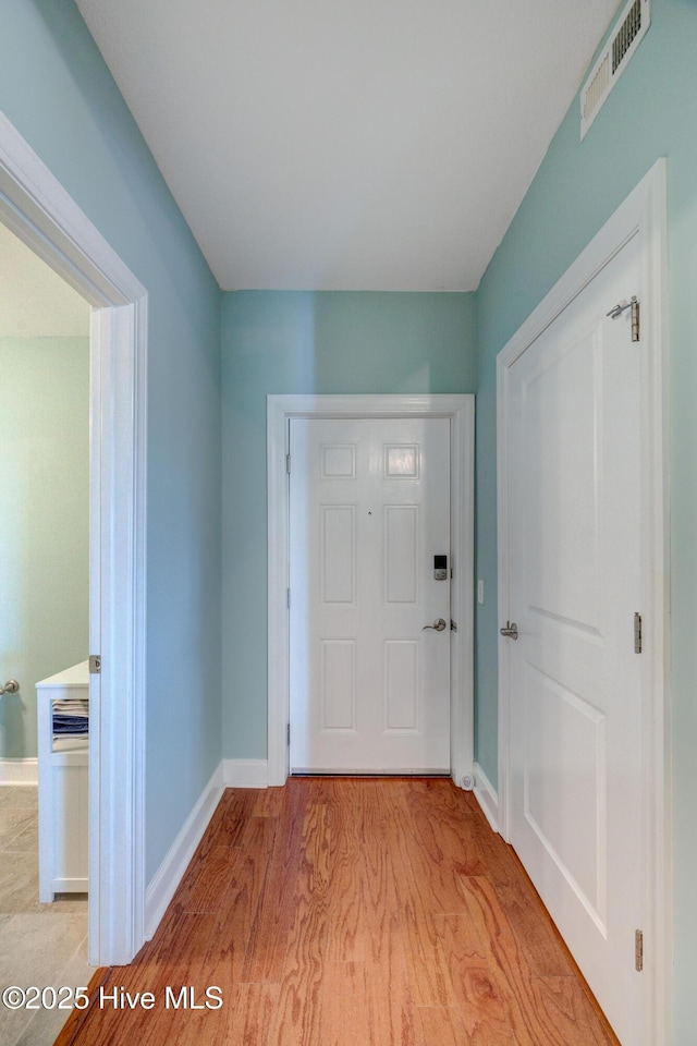 foyer entrance featuring light wood-style floors, baseboards, and visible vents