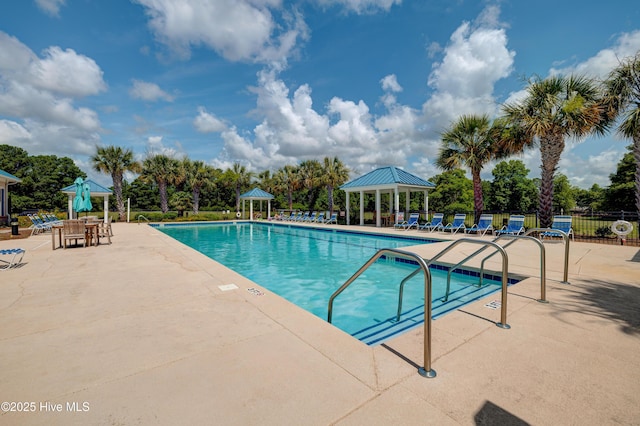 pool with a patio area, fence, and a gazebo