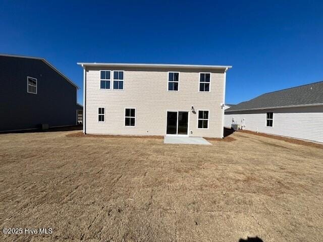 rear view of house with a patio area and a lawn