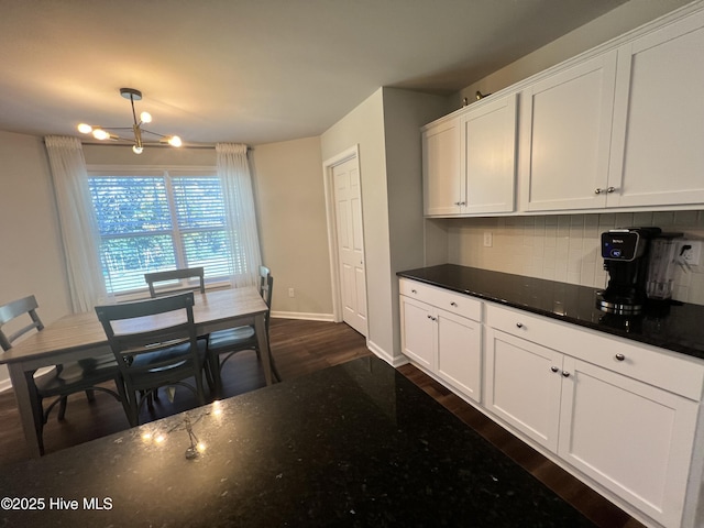 kitchen with white cabinetry, backsplash, dark hardwood / wood-style flooring, and decorative light fixtures