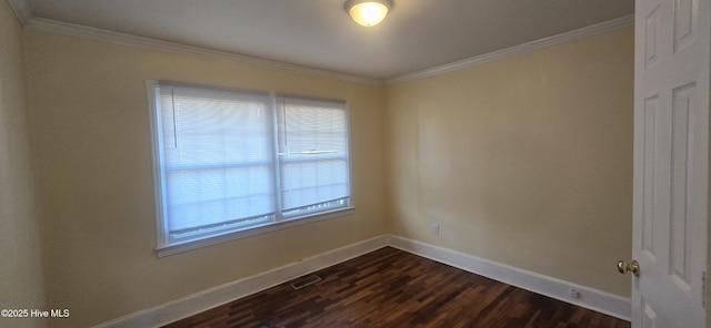 unfurnished room featuring dark wood-style floors, crown molding, visible vents, and baseboards