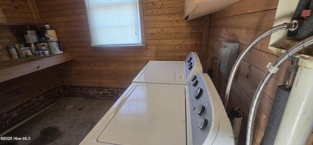 washroom with laundry area, washing machine and dryer, and wooden walls