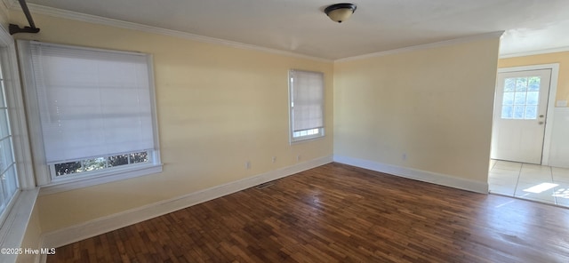 unfurnished room with ornamental molding, wood finished floors, visible vents, and baseboards