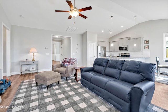 living room with vaulted ceiling, ceiling fan, and hardwood / wood-style floors