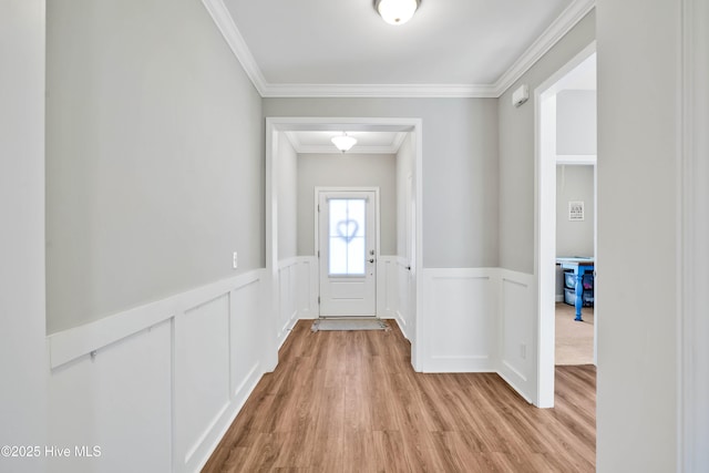 doorway featuring crown molding and light wood-type flooring