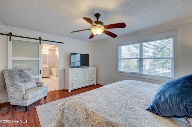 bedroom with crown molding, wood-type flooring, a textured ceiling, ceiling fan, and a barn door