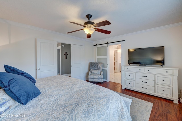 bedroom featuring crown molding, dark wood-type flooring, a barn door, and ceiling fan