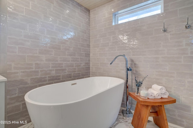 bathroom featuring tile walls and a tub