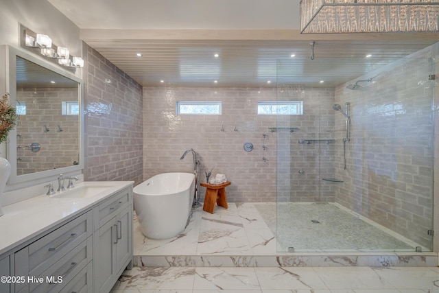 bathroom with vanity, separate shower and tub, and tile walls