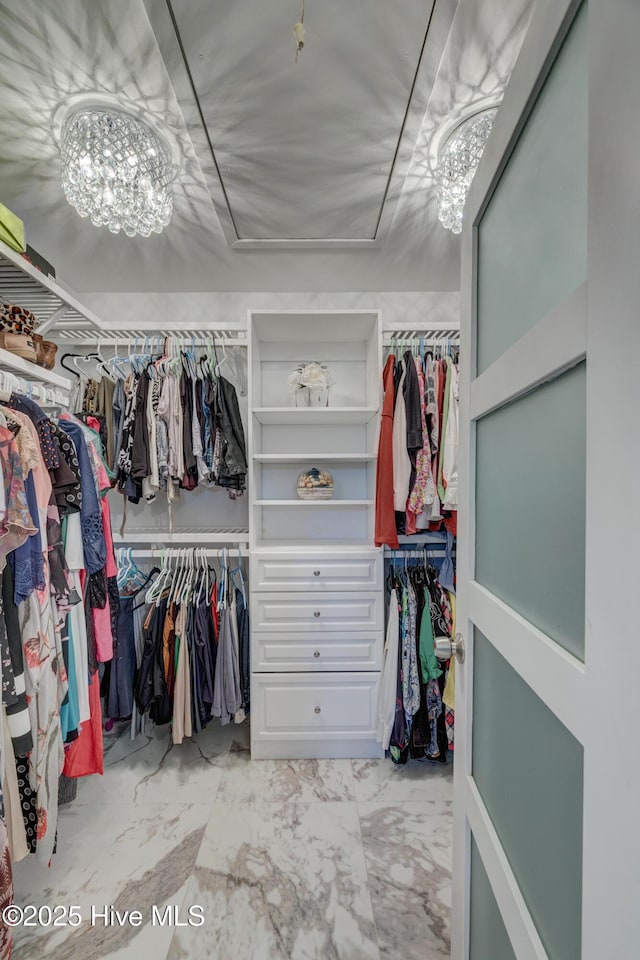 spacious closet with a chandelier