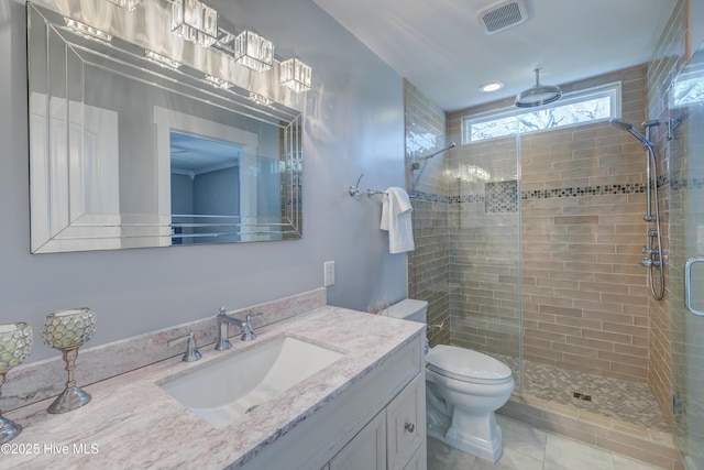 bathroom with tile patterned floors, vanity, toilet, and a shower with door