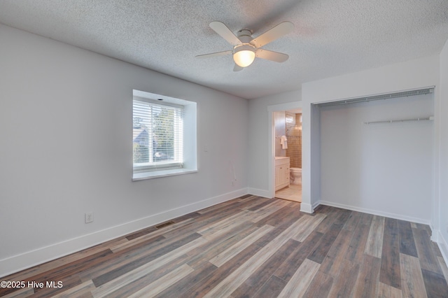 unfurnished bedroom featuring dark wood-type flooring, ceiling fan, a closet, and a textured ceiling