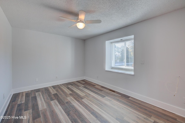 spare room with ceiling fan, a textured ceiling, and dark hardwood / wood-style flooring